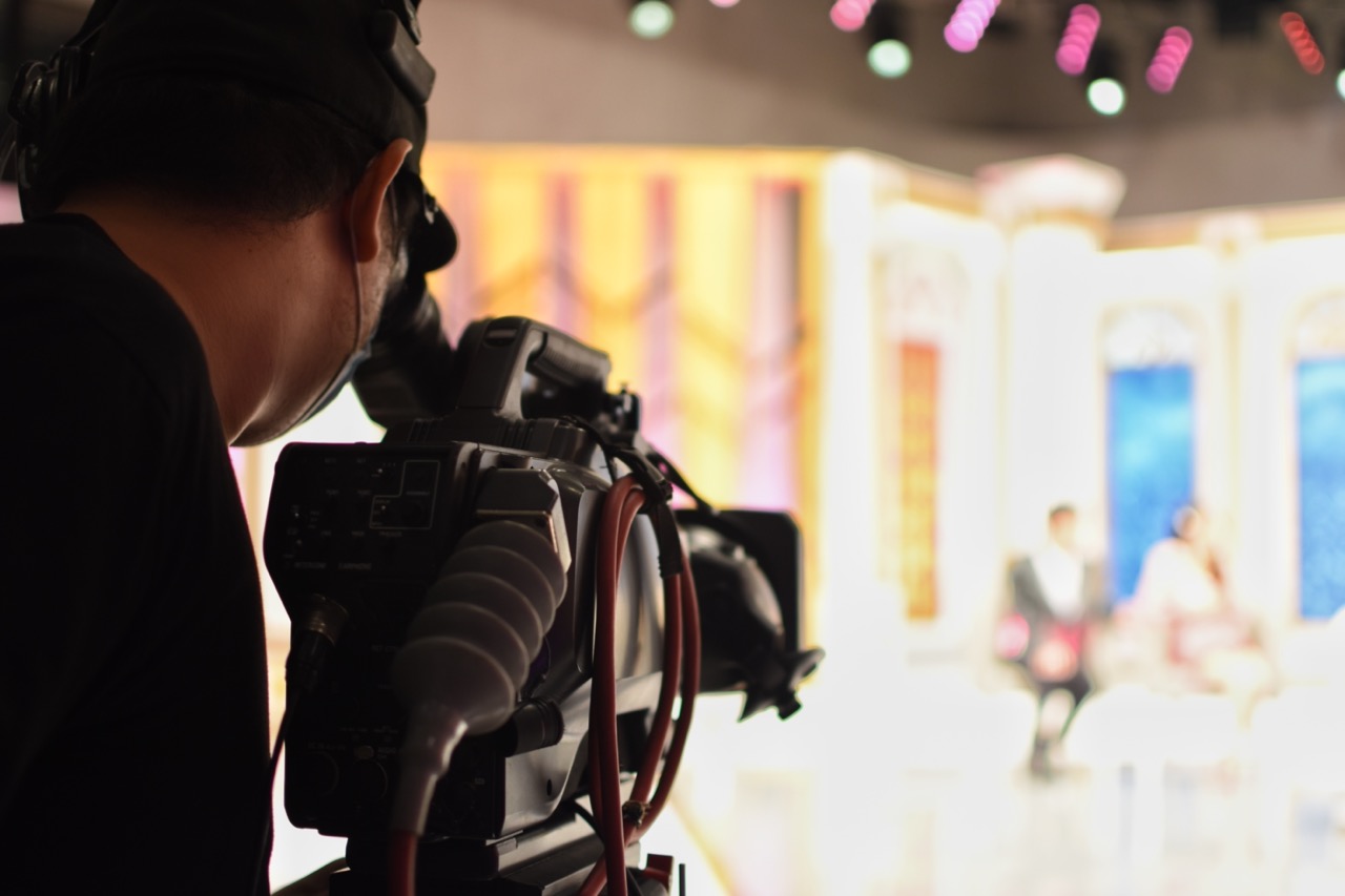 an over the shoulder vantage point of a camera man operating a television camera